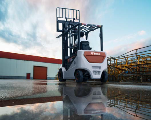 a person driving a Bobcat forklift outdoors